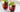 two red iced beverages with berries and herbs in short glasses