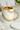 Speckled ceramic mug with gold mesh loose leaf tea infuser and rainbow handle being filled with tea.