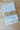 Two folded towels with blue patterns on a wooden surface