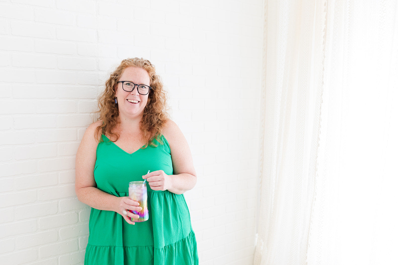 Katie McDonald, owner of Full Moon Tea Company loose leaf tea smiling and holding a glass of iced tea.