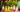 A row of colorful tea mocktails in fun shaped glasses with fruit garnishes over ice on a patio with lights and greenery