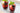 two red iced beverages with berries and herbs in short glasses