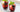 two red iced beverages with berries and herbs in short glasses