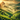 Tea farm with green hills at sunset in a cloudy sky with trees and tea farmers