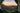 Picture of sunset over the mountains through the door of a tent with a stainless steel mug