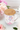 Mug with floral design and wooden lid on a table with flowers and macarons.