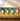 Eight colorful tea tins from Tea Moon Tea Company arranged in a row on a wooden shelf. The labels show different tea flavors: Strawberry Breakfast, Suede Moon Mint, Sun Moon Cowboy Coffee, Ginger, Pear & Peach, Goddess Gray, Full Moon Breakfast, Full Moon Lunch, Full Moon Dinner, and Full Moon Awener.