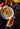 Hand holding a mug of hot chocolate with cinnamon sticks and a pear in the background