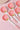 Set of ceramic spoons with strawberry design on a pink background