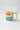 Mug with rainbow stripes and a yellow handle on a light gray background
