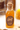 Bottle of 'The Ramblin' Bee' local honey on a wooden surface with blurred background